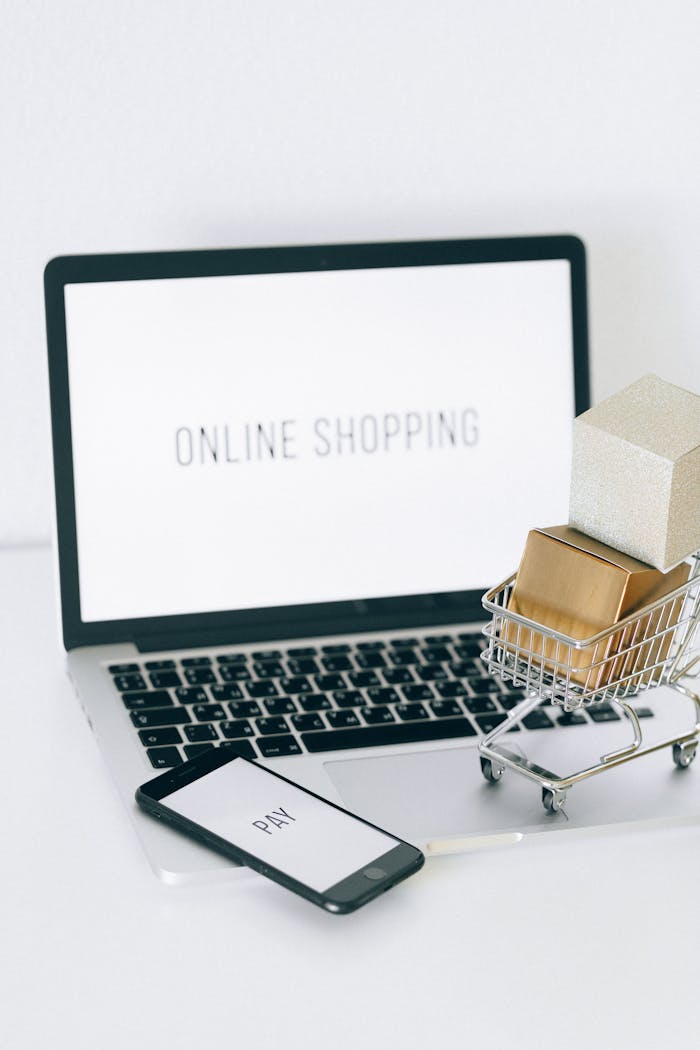 about-us Minimalist setup showcasing online shopping with a laptop and miniature cart.